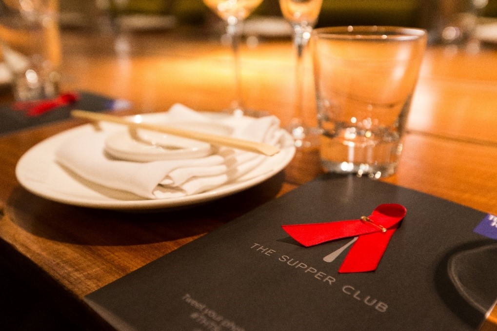 Table at The Supper Club restaurant with menu and red ribbon