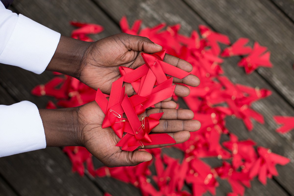 World AIDS day red ribbons in hands World AIDS day red ribbons in hands