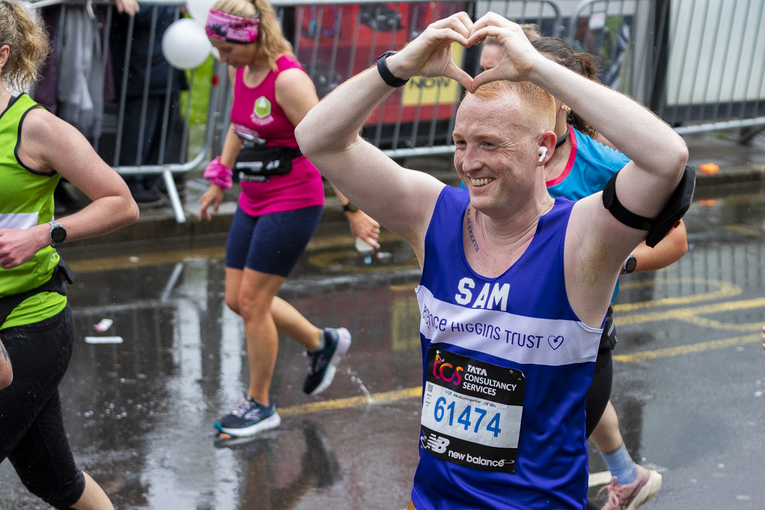 Marathon runner Sam in Terrence Higgins Trust T-shirt, making heart with hands